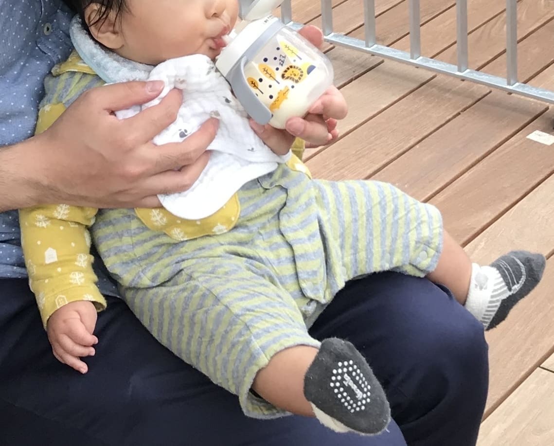 ストローマグでミルクを飲む赤ちゃん